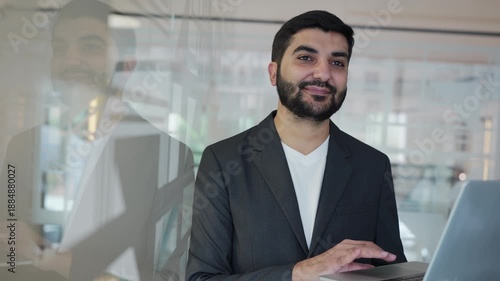 Professional man working on computer in glass office