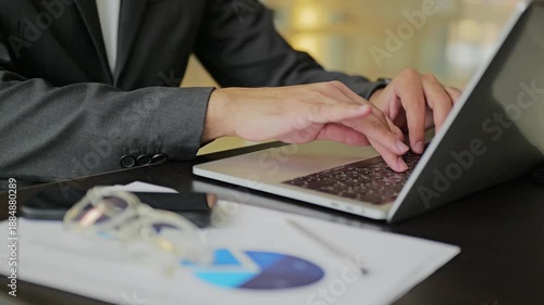 Corporate worker typing on laptop at workplace