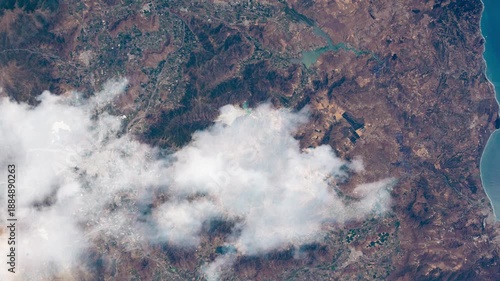 Flying over Chilean coastal mountains and protected natural reserves with passing clouds, animation based on Nasa imagery