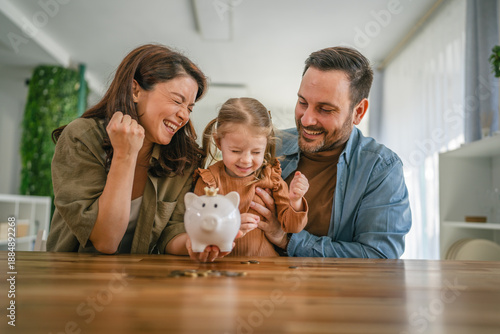 Obraz na płótnie Family teaching child about saving money with piggy bank