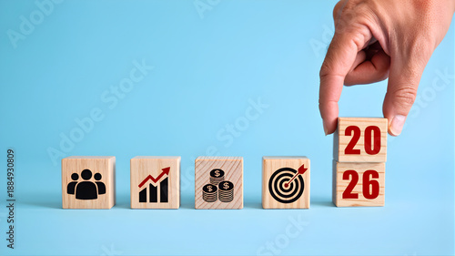 Strategic business planning for 2026, with wooden blocks showing icons of teamwork, financial growth, and target achievement, highlighting future goals and success