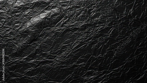 Textured close-up shot of a crumpled, matte black surface with detailed wrinkles