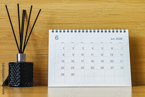 Office desk calendar showing June 2026 with copy space on wooden background, ideal for business planning, scheduling, and time management concepts.