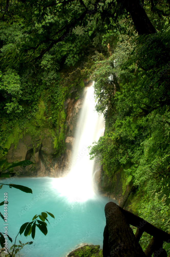 Obraz premium Long exposure shot of the Rio Celeste waterfall in Tenorio Volcano National Park, Costa Rica, showing silky smooth white water cascading into a vibrant turquoise pool.