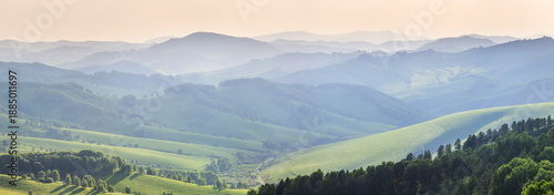 Ridge gradients in haze, panoramic view of the summer evening, hills and mountain slopes in sunset light