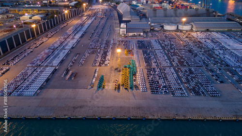 Wallpaper Mural Aerial night view of a massive automotive port terminal filled with thousands of new cars ready for export. Industrial logistics landscape with rows of parked vehicles illuminated by floodlights  Torontodigital.ca