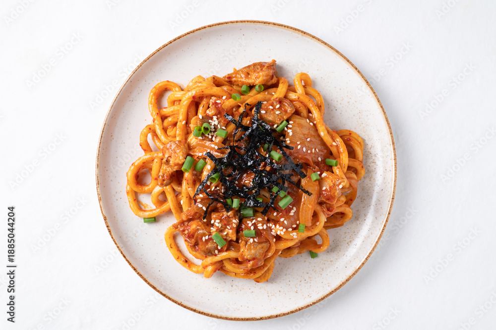 Fototapeta premium Top view of Stir fried Udon noodle with kimchi cabbage, pork, spring onion, sesame seed and seaweed on white background