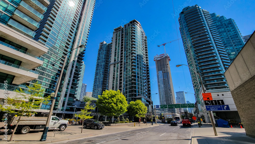 Fototapeta premium Urban street view of downtown toronto, canada, featuring tall modern residential and commercial skyscrapers, with a visible construction site and directional sign pointing to st. Lawrence market
