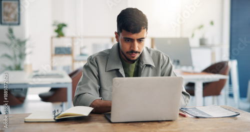 Obraz na plátne Creative, man and reading with laptop in office for research, proofreading and copywriting report