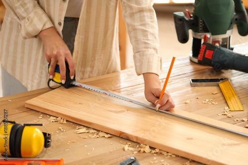 Young female carpenter with...