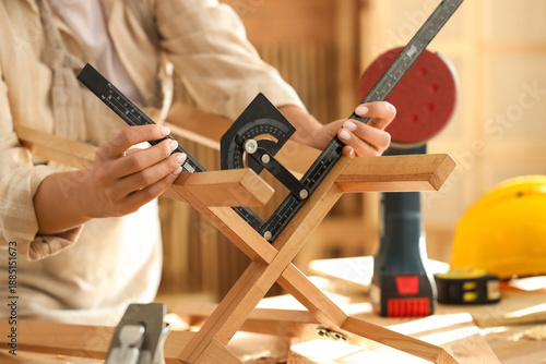 Young female carpenter meas...