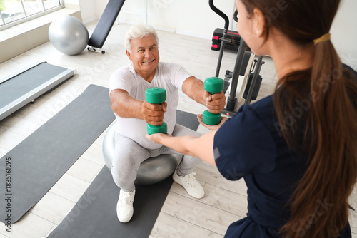 Senior man with dumbbells a...