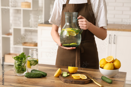 Young woman holding jug of ...
