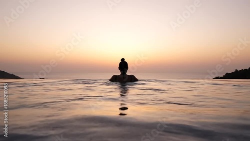 Wallpaper Mural Silhouette of a woman enjoying a peaceful sunset swim in an infinity pool overlooking the ocean. Torontodigital.ca