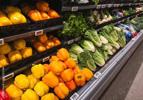 Valokuva Variety of peppers, lettuce and produce on shelves in supermarket