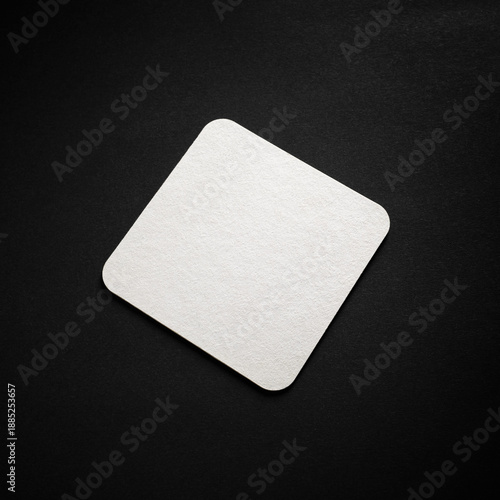 Blank square beer coaster mockup on black surface.