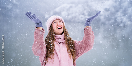 Quadro su tela Portrait of a smiling woman catching snowflakes near a snowy mountain lake, happ