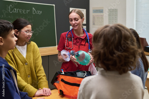 Photos Caucasian young adult woman paramedic demonstrating medical resuscitator mask to