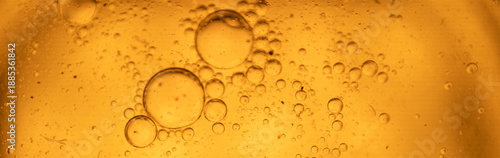 Obraz na płótnie Close-up of a golden, viscous liquid with droplets and large circular bubbles, perfect for product or science background imagery, conveying purity and luxury