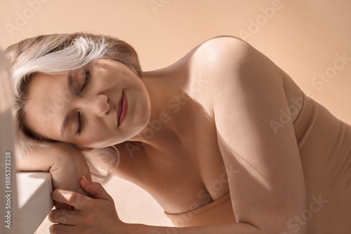Foto Female model with light hair, resting her head on her arm, showcasing serene exp