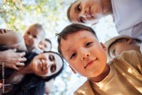 Wallpaper Mural Group of children and adults smiling together outdoors, captured from a low angle, surrounded by greenery, showcasing joy and connection in a vibrant atmosphere Torontodigital.ca