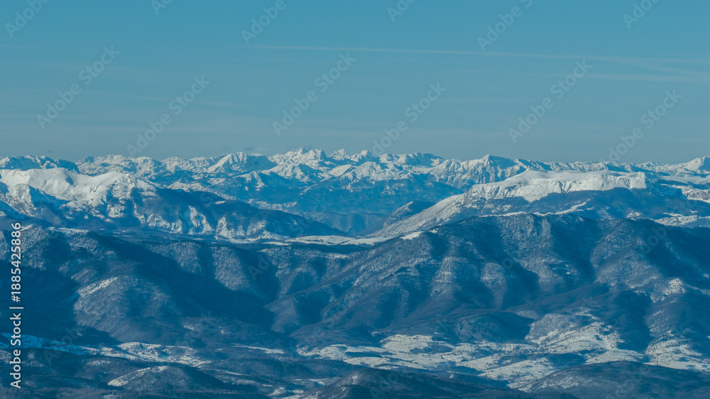 Fototapeta premium Wide panoramic view of Treskavica mountain range in winter, revealing snow covered ridges, deep valleys, and expansive alpine wilderness