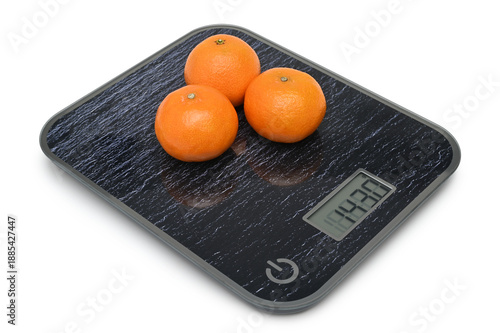 Fresh tangerines on digital kitchen scales
