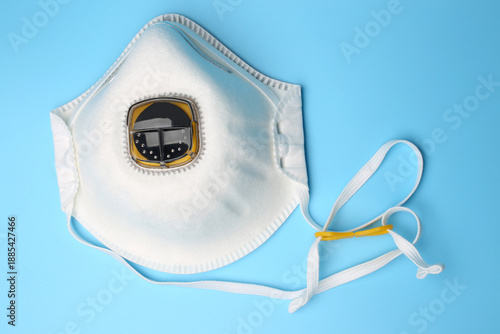 Filtering half mask with exhalation valve on blue background