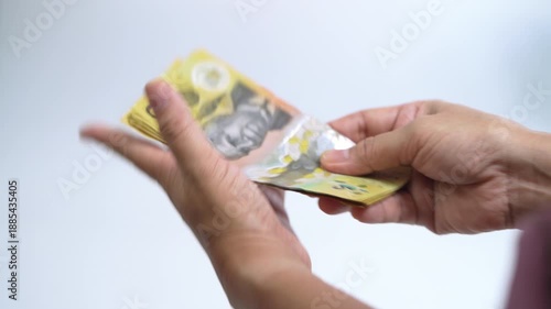 Hands counting Australian dollar banknotes and handing cash to another person, representing payment, financial transaction, income, business exchange, savings, and money management.