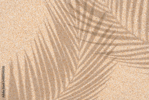 Beach sand surface with soft tropical palm leaf shadow,sunlight.Natural ripples of warm summer aesthetic,Top view tropical sea sand texture for summer vibes,travel branding, spa organic product mockup