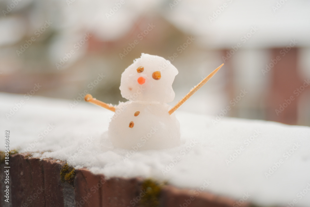Obraz premium Tiny Snowman on Balcony Edge with Street in Background 