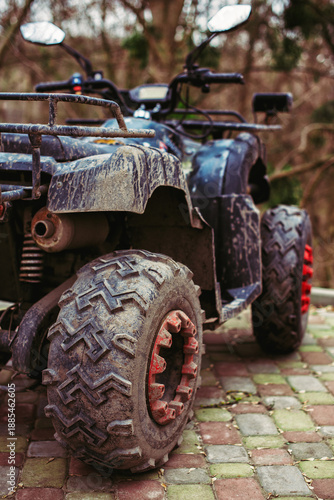 Muddy ATV parked outdoors rear view