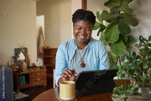 Smiling young African woman talking on a video call using a tablet