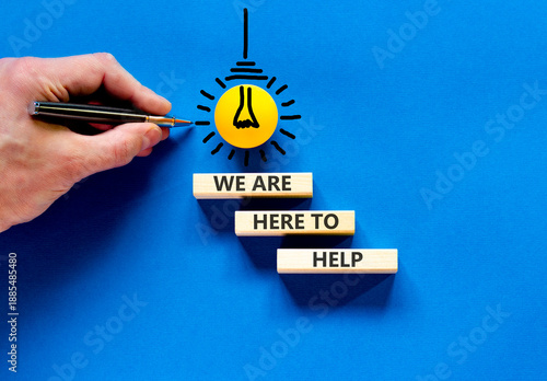 Support, help and we are here to help symbol. Concept words We are here to help on beautiful wooden blocks. Beautiful blue background. Business we are here to help concept. Copy space.