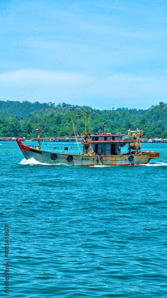 Fototapeta premium An old wooden fishing schooner goes out to catch fish and shrimp. Malaysia, South China Sea.