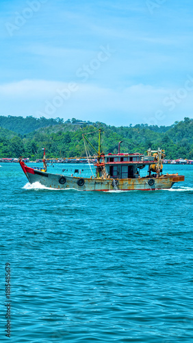 An old wooden fishing schooner goes out to catch fish and shrimp. Malaysia, South China Sea.