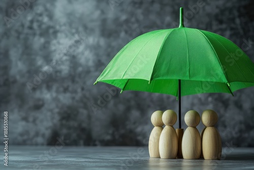 Wallpaper Mural A green umbrella and wooden mannequins on a table. The concept of family protection Torontodigital.ca