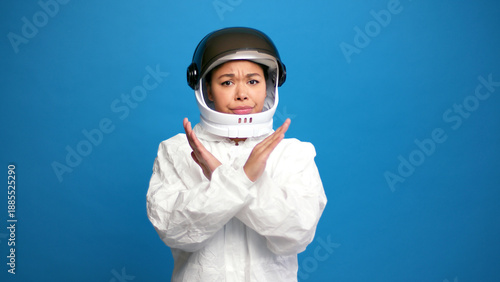 Bild auf Leinwand Sad, serious hispanic woman nods no showing stop gesture wearing helmet and spac