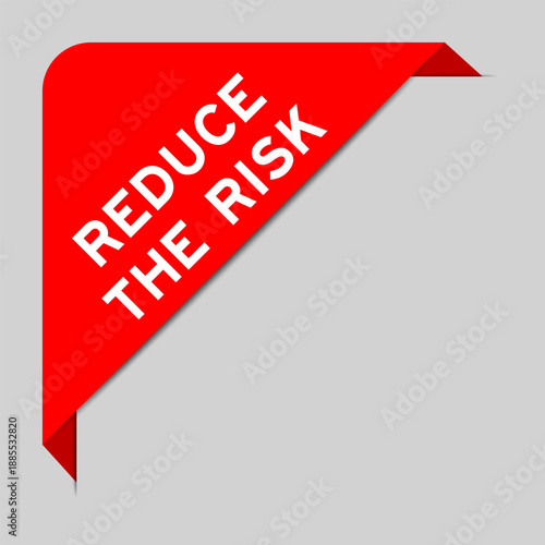 Red color of corner label banner with word reduce the risk on gray background