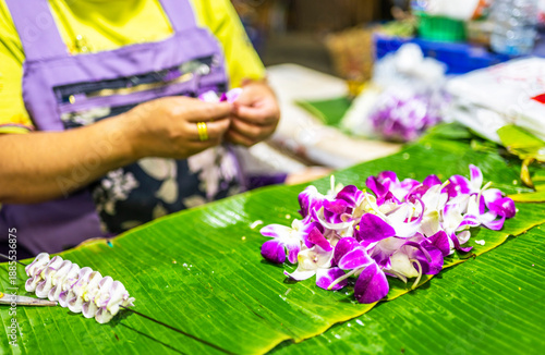 Flower seller prepares purple orchids,inside Pak Khlong Talat,the primary flower market of Bangkok,Thailand.
