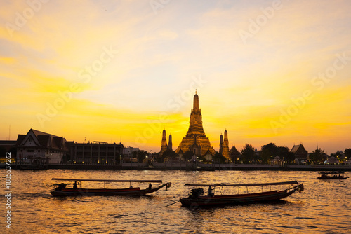 Riverboats at sunset,next to the Arun Temple,along the Cha Phraya River,Bangkok.