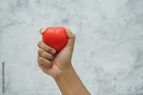 Wallpaper Mural Hand holding a red heart symbol representing love, care, and emotional connection. Torontodigital.ca