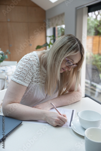 Close-up of woman journaling at home with deep concentration and calm focus