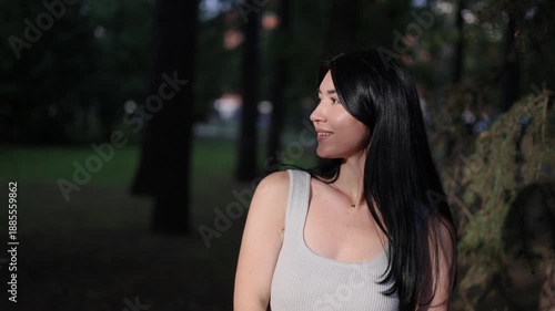 Portrait of a young attractive brunette woman in a park in the sun