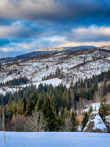 Mystical snowy Carpathian peaks under cloudy skies in the sunny weather