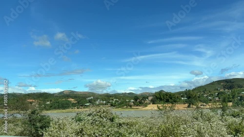 Agricultural land and scattered trees flow gently across the frame as the viewpoint travels forward, slow motion highlighting distance, air, and unhurried rural surroundings. Simple living.