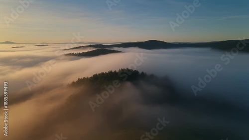 Dramatic aerial view of mountains covered in early morning fog