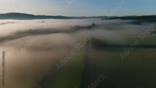 Aerial view of a foggy landscape at sunrise or sunset.