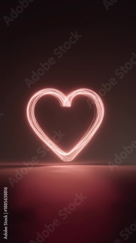 Neon heart sign glowing in warm pink light on dark background  