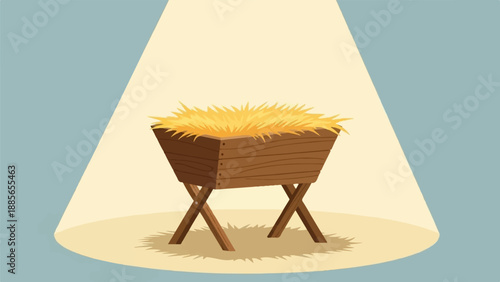 Empty wooden manger filled with straw bathed in a spotlight